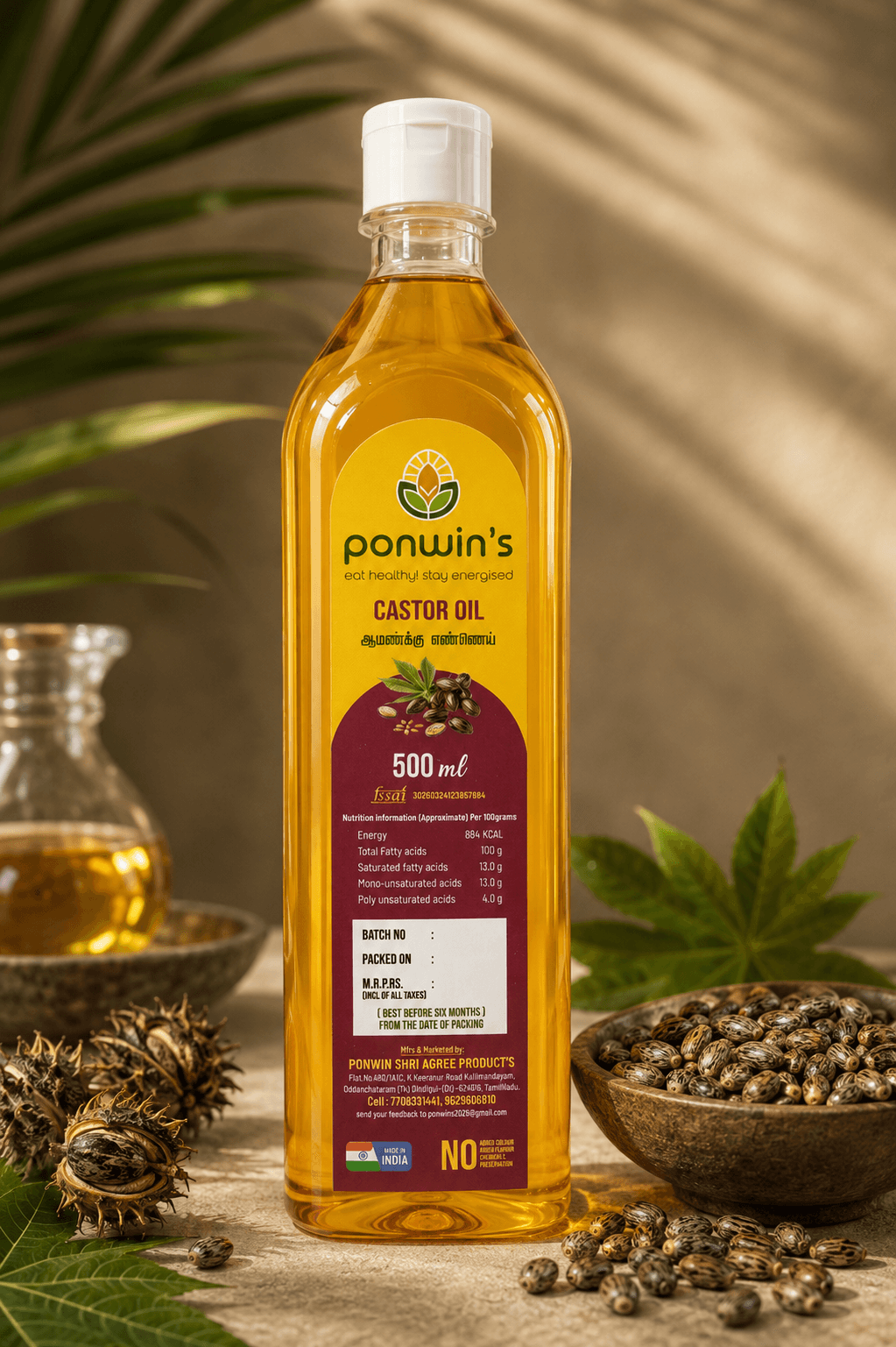 Castor leaves and seeds beside a bottle of Ponwin's castor oil